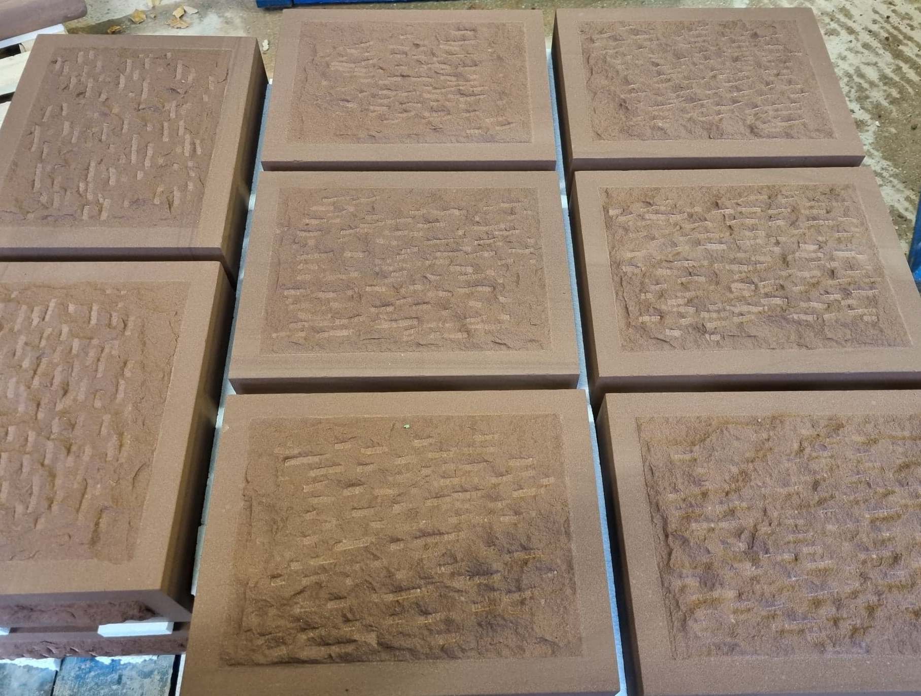 Nine beige textured square panels arranged in a grid on a tabletop.