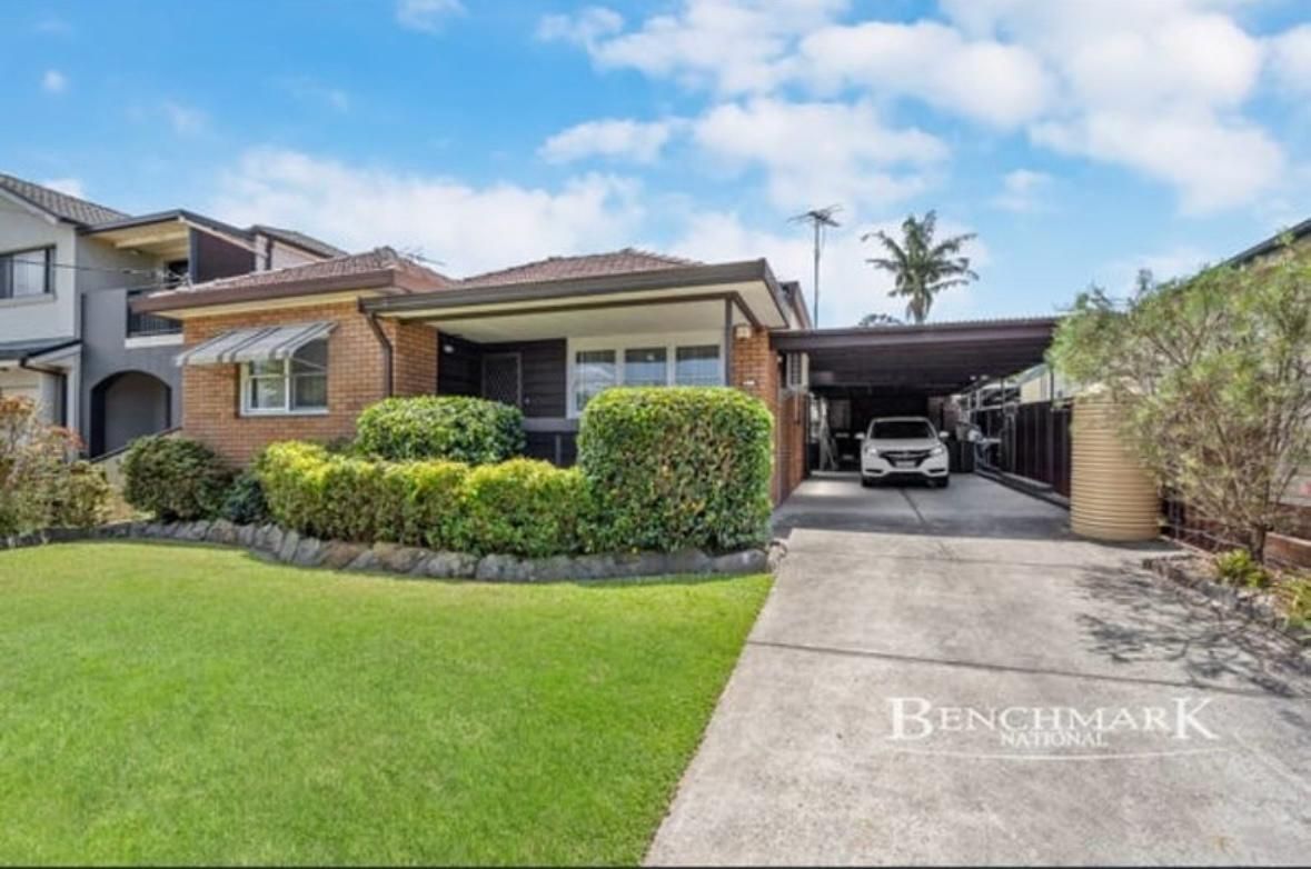 A car is parked in a driveway in front of a house.