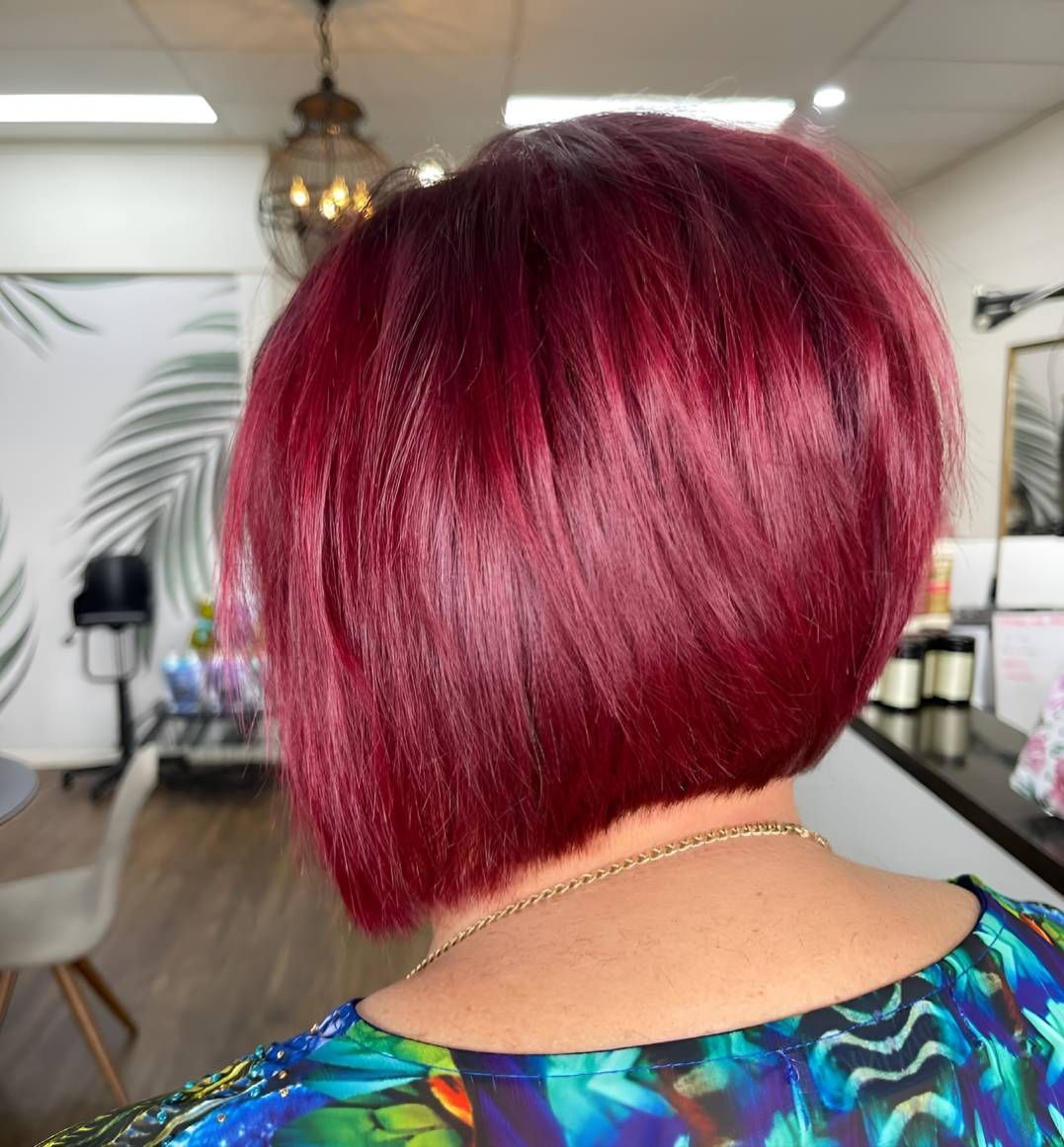 A Woman With Red Hair Is Wearing A Blue Shirt — Beautique Hair Lounge & Beauty Bar In Kelso, QLD