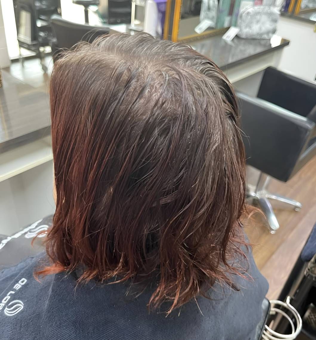 A Woman Is Getting Her Hair Cut — Beautique Hair Lounge & Beauty Bar In Kelso, QLD