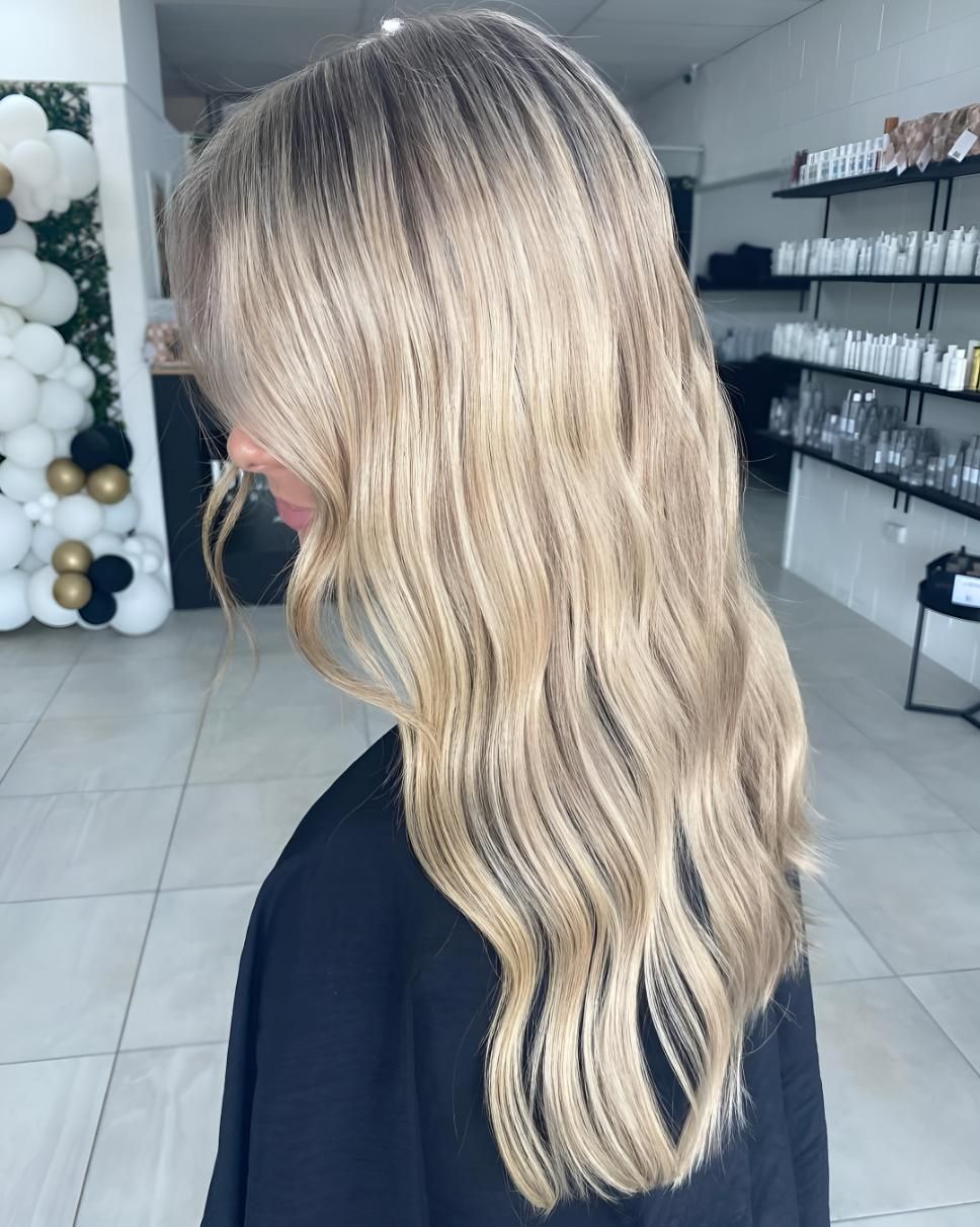A Woman With Long Blonde Hair Is Standing In A Salon — Beautique Hair Lounge & Beauty Bar In Charters Towers, QLD