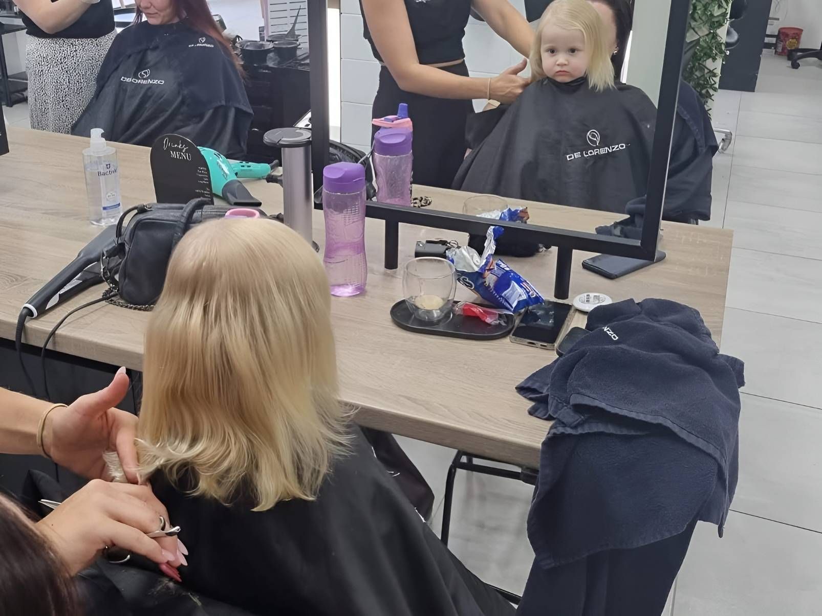 A Little Girl Is Getting Her Hair Cut In A Salon — Beautique Hair Lounge & Beauty Bar In Condon, QLD