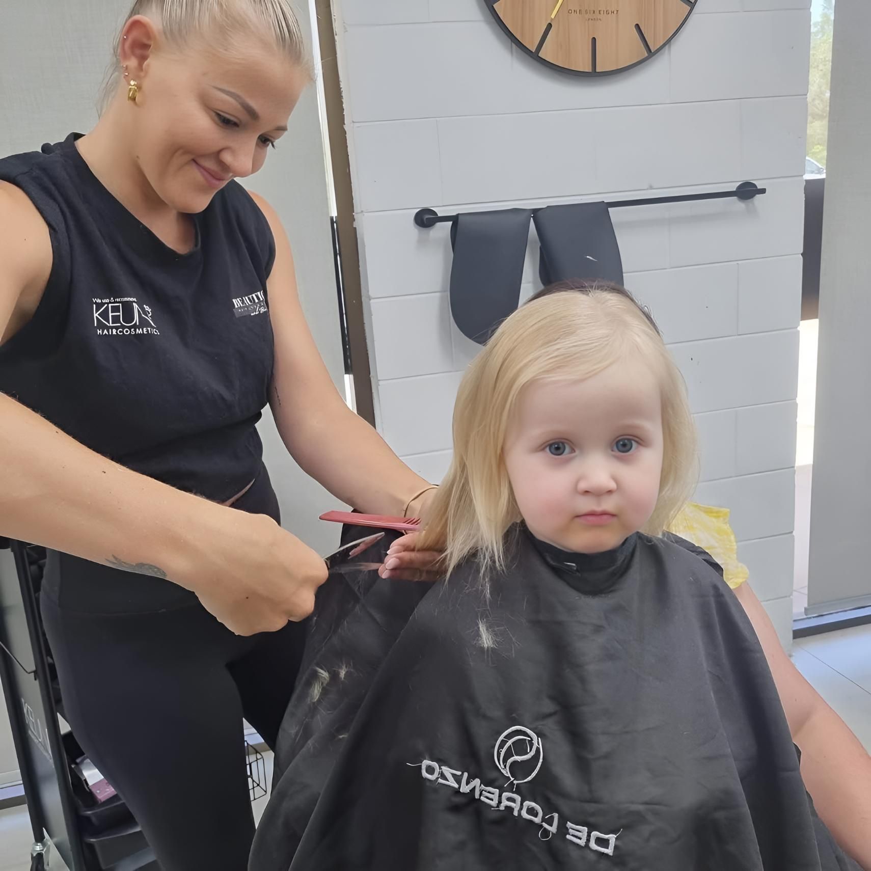 A Little Girl Is Getting Her Hair Cut — Beautique Hair Lounge & Beauty Bar In Condon, QLD