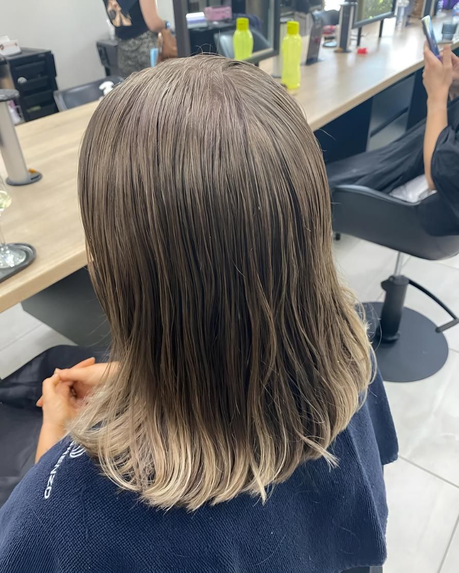 A Woman Is Getting Her Hair Cut In A Salon — Beautique Hair Lounge & Beauty Bar In Condon, QLD