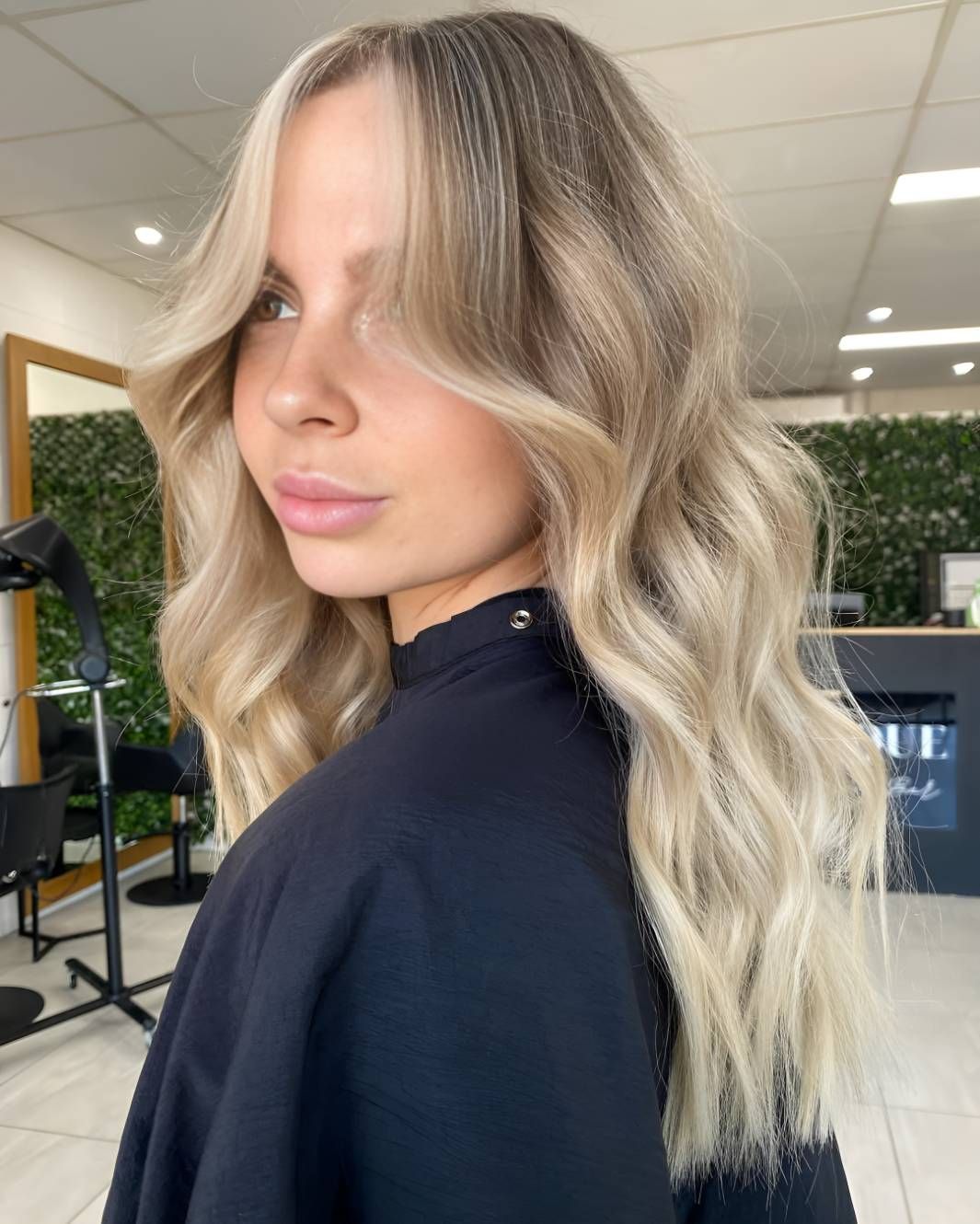 A Woman With Blonde Hair Is Standing — Beautique Hair Lounge & Beauty Bar In Rasmussen, QLD