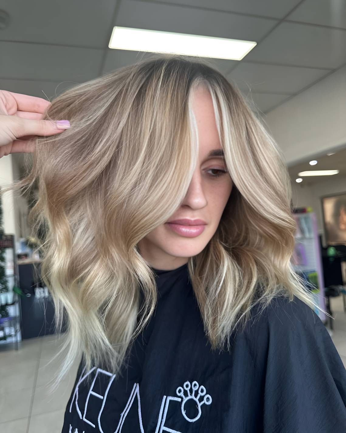 A Woman With Blonde Hair Is Wearing A Black Shirt — Beautique Hair Lounge & Beauty Bar In Condon, QLD