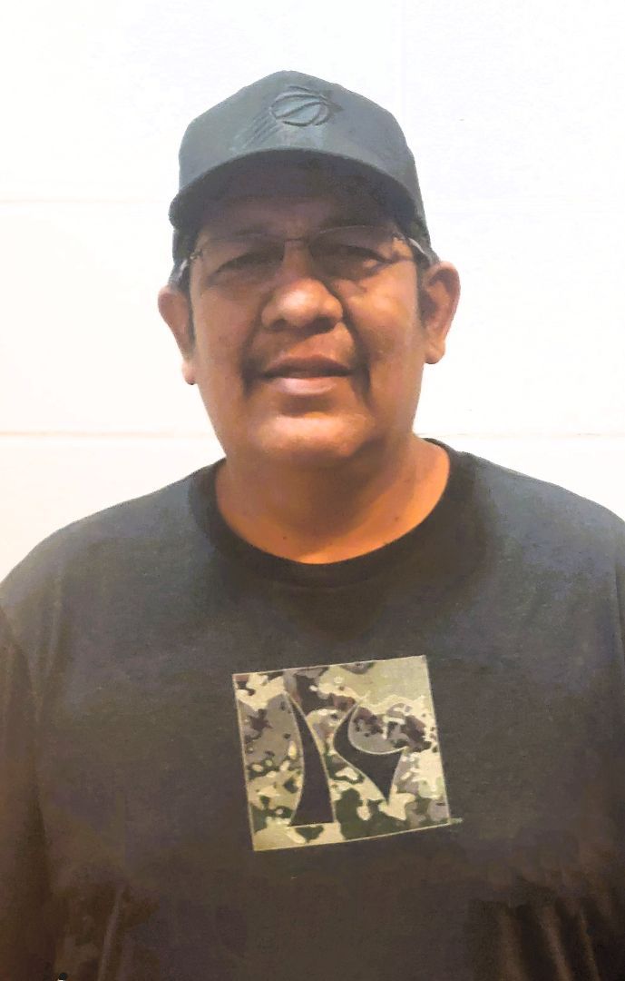 A man wearing a black hat and a black shirt