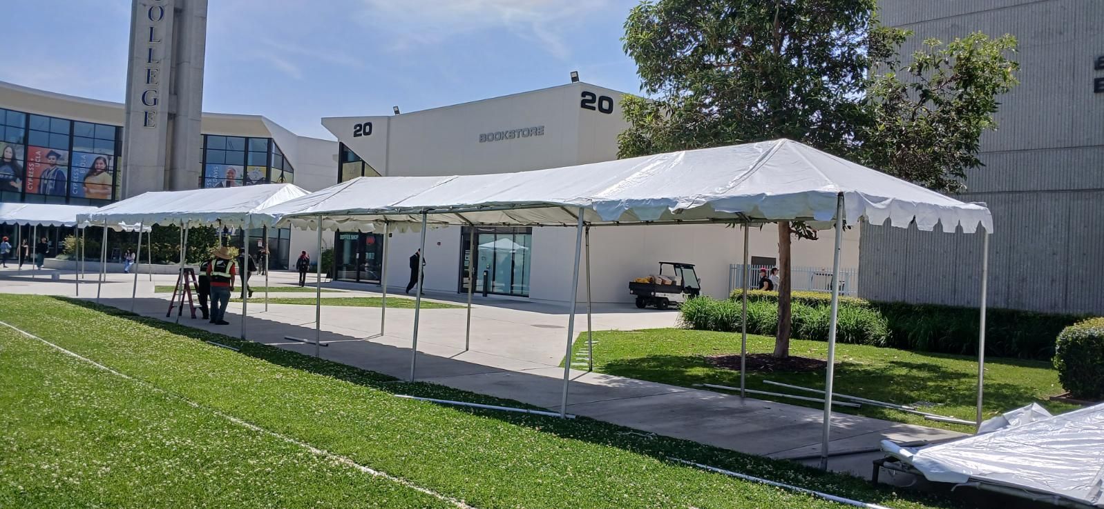 A large white tent is sitting in front of a building.