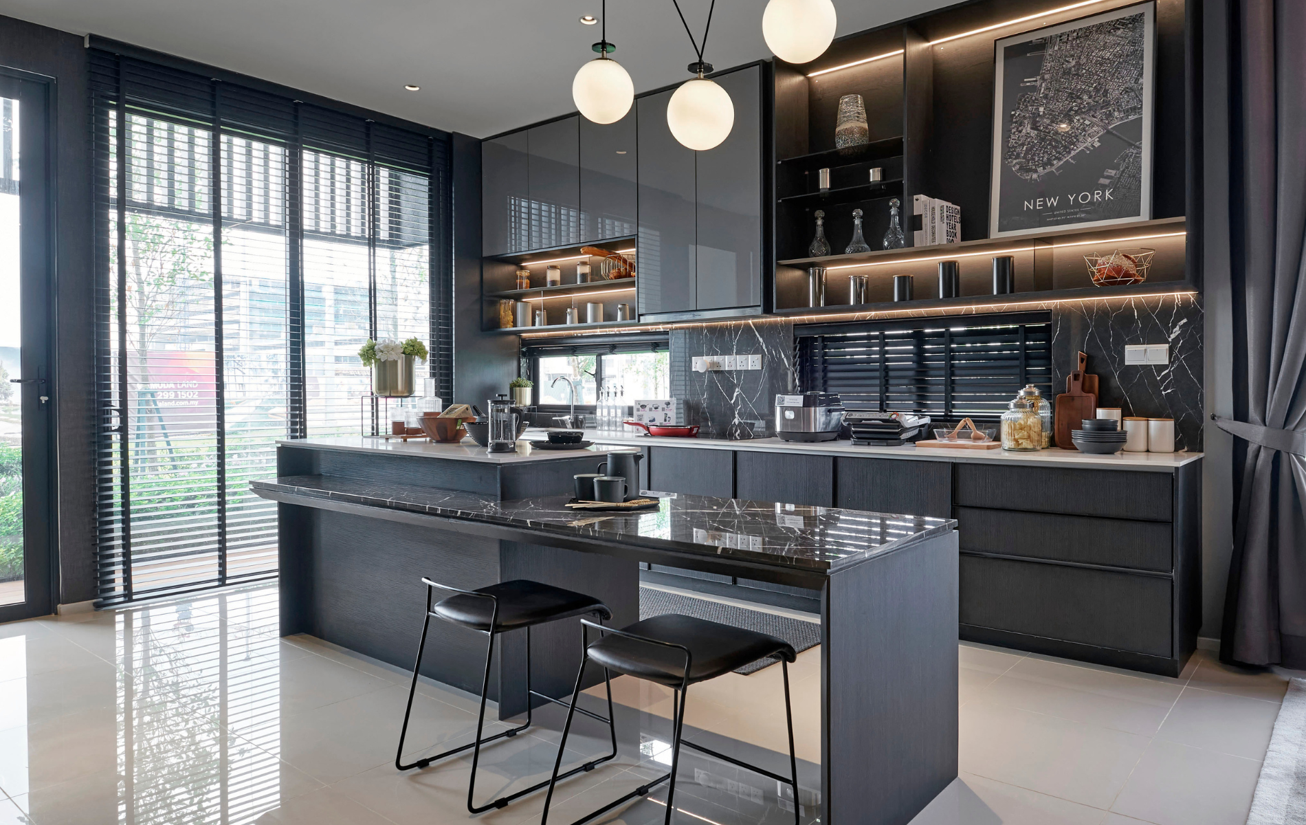 Modern black kitchen with island, pendant lights, and large windows overlooking a patio