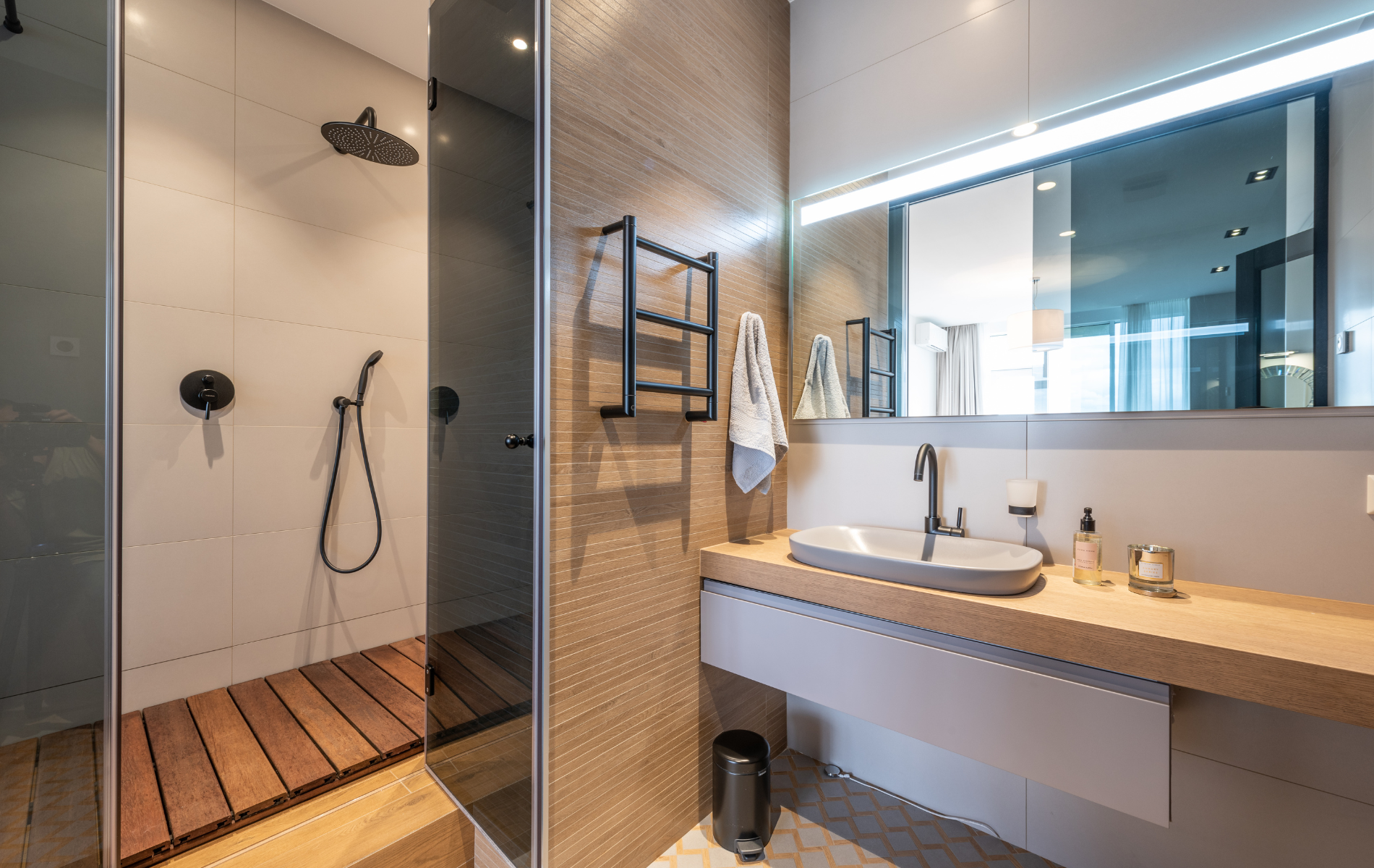 A bathroom with a sink , shower and mirror.