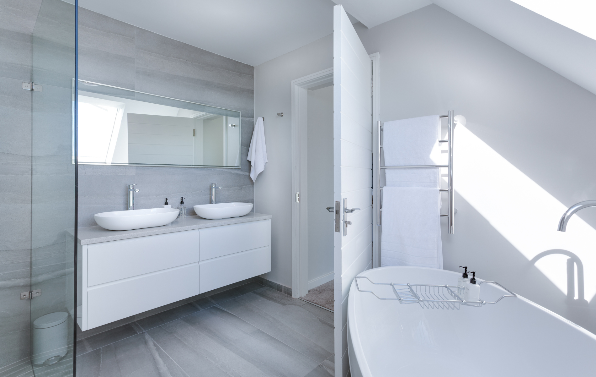 A bathroom with two sinks , a bathtub and a walk in shower.
