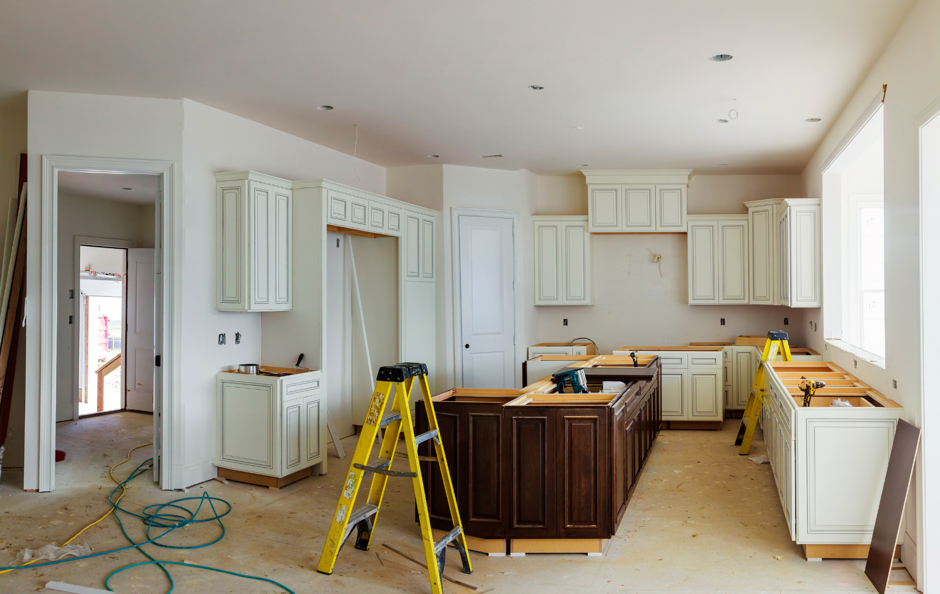 A kitchen under construction with a ladder in the middle of the room.