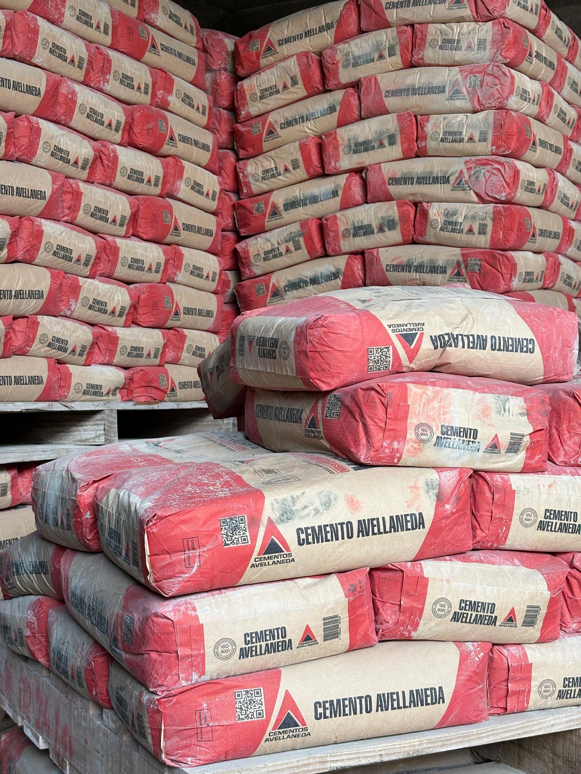 Sacos de cemento Portland blancos apilados sobre palés de madera al aire libre
