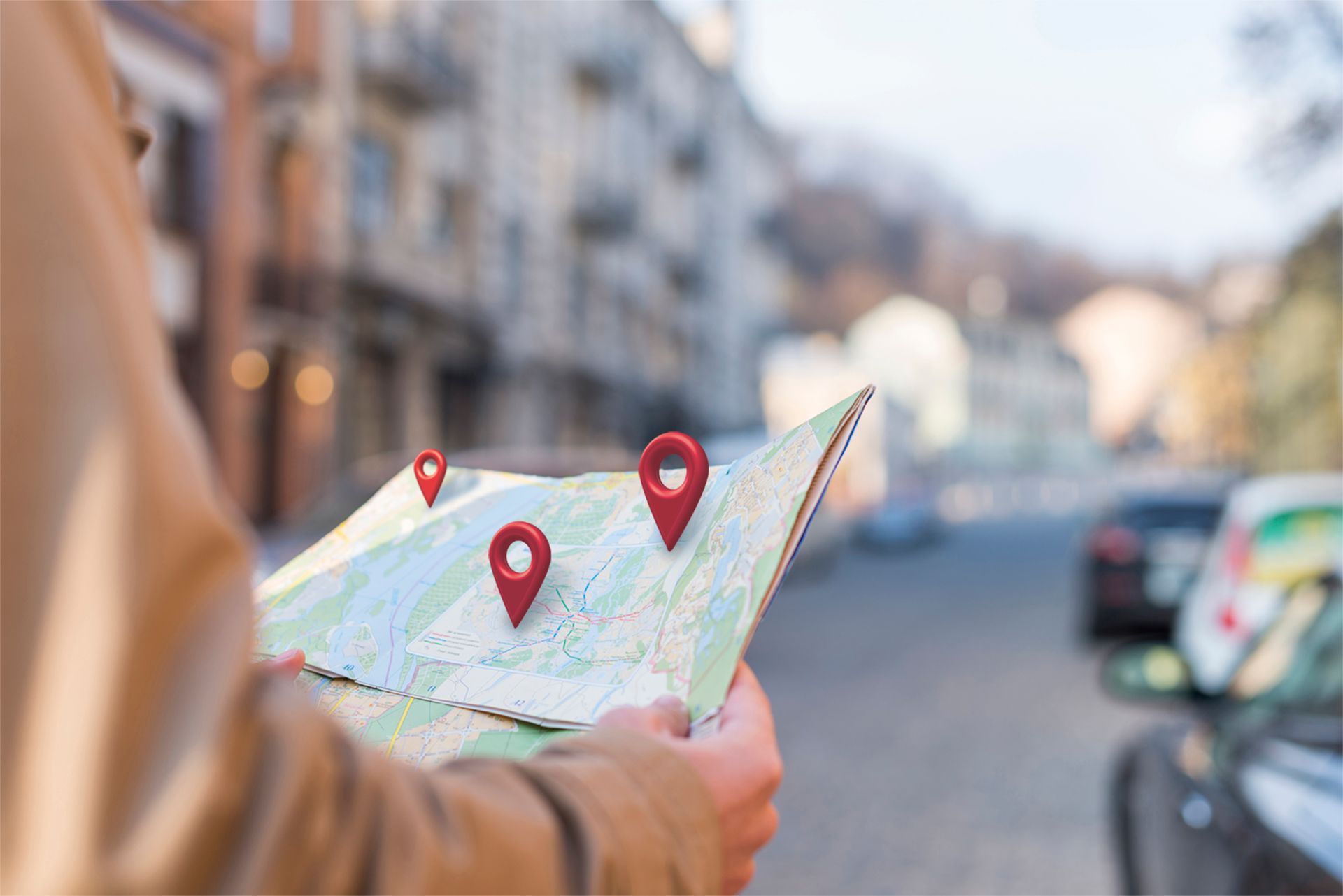 Person holding a map with location markers on a city street.