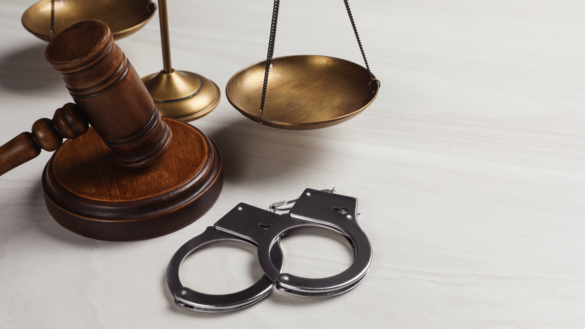 A man in a suit and tie is sitting at a table with a judge 's gavel and scales of justice.
