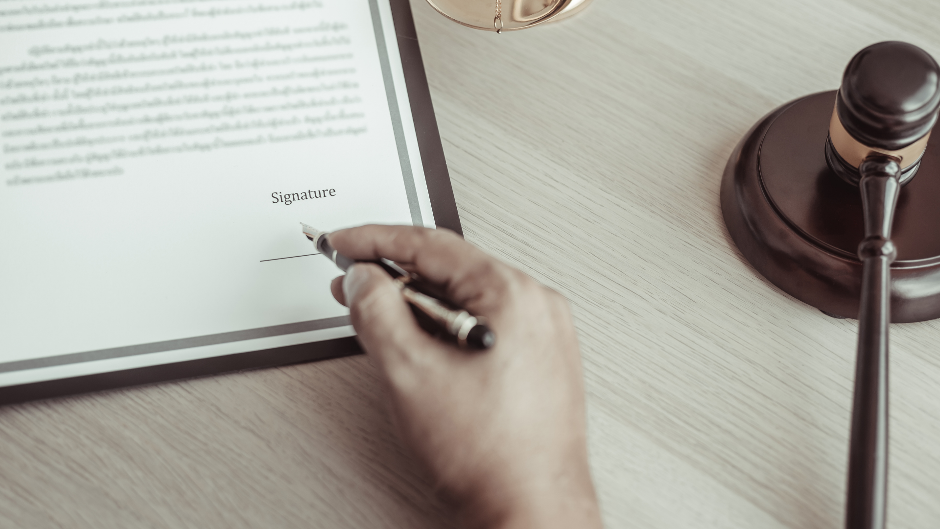 A wooden judge 's gavel is sitting on a table in front of a stack of books.