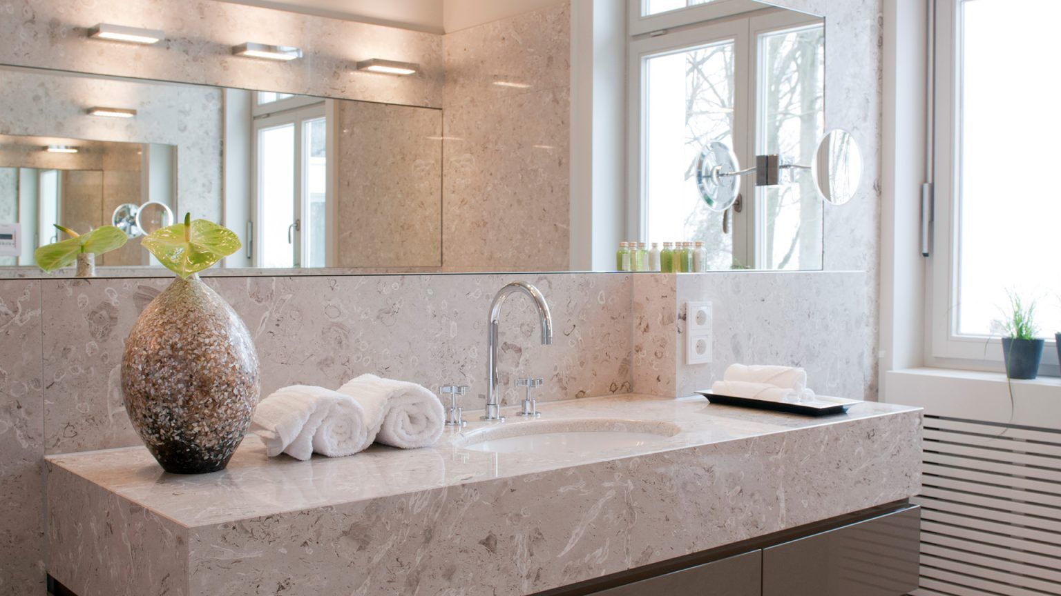 Ein Badezimmer mit Waschbecken, Spiegel und Fenster.