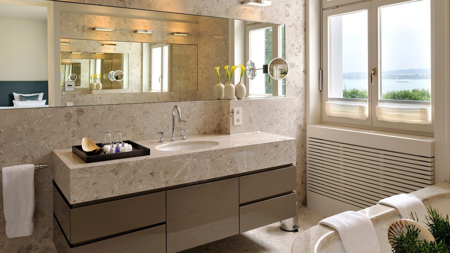 Ein Badezimmer mit Badewanne, Waschbecken, Spiegel und Fenster