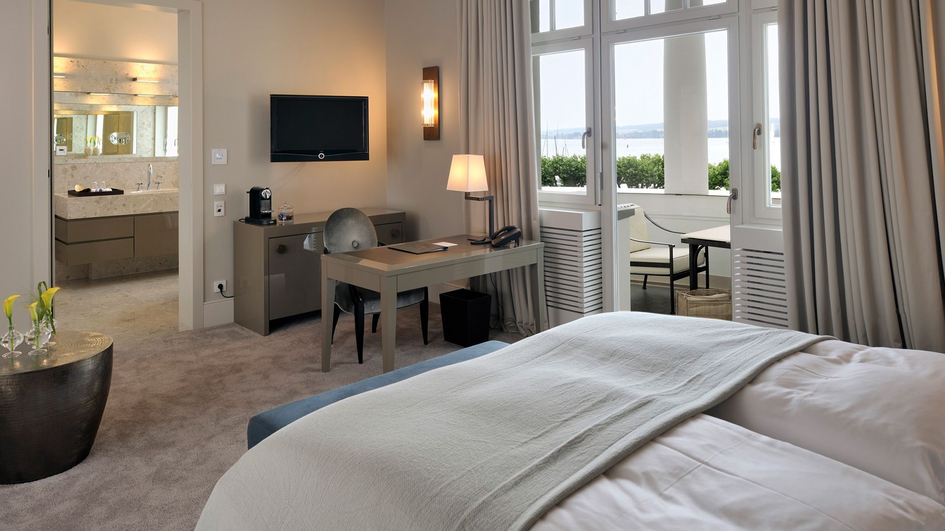 Ein Hotelzimmer mit Bett, Schreibtisch und Fernseher