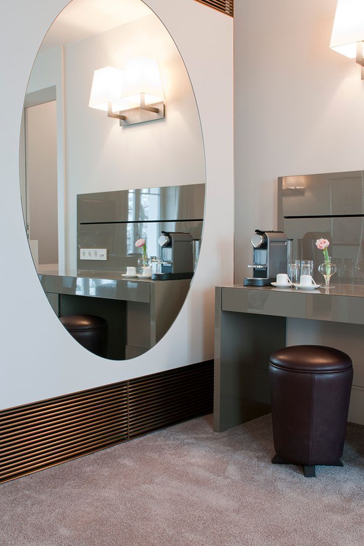 Ein Zimmer mit einem großen Spiegel und einem Schreibtisch