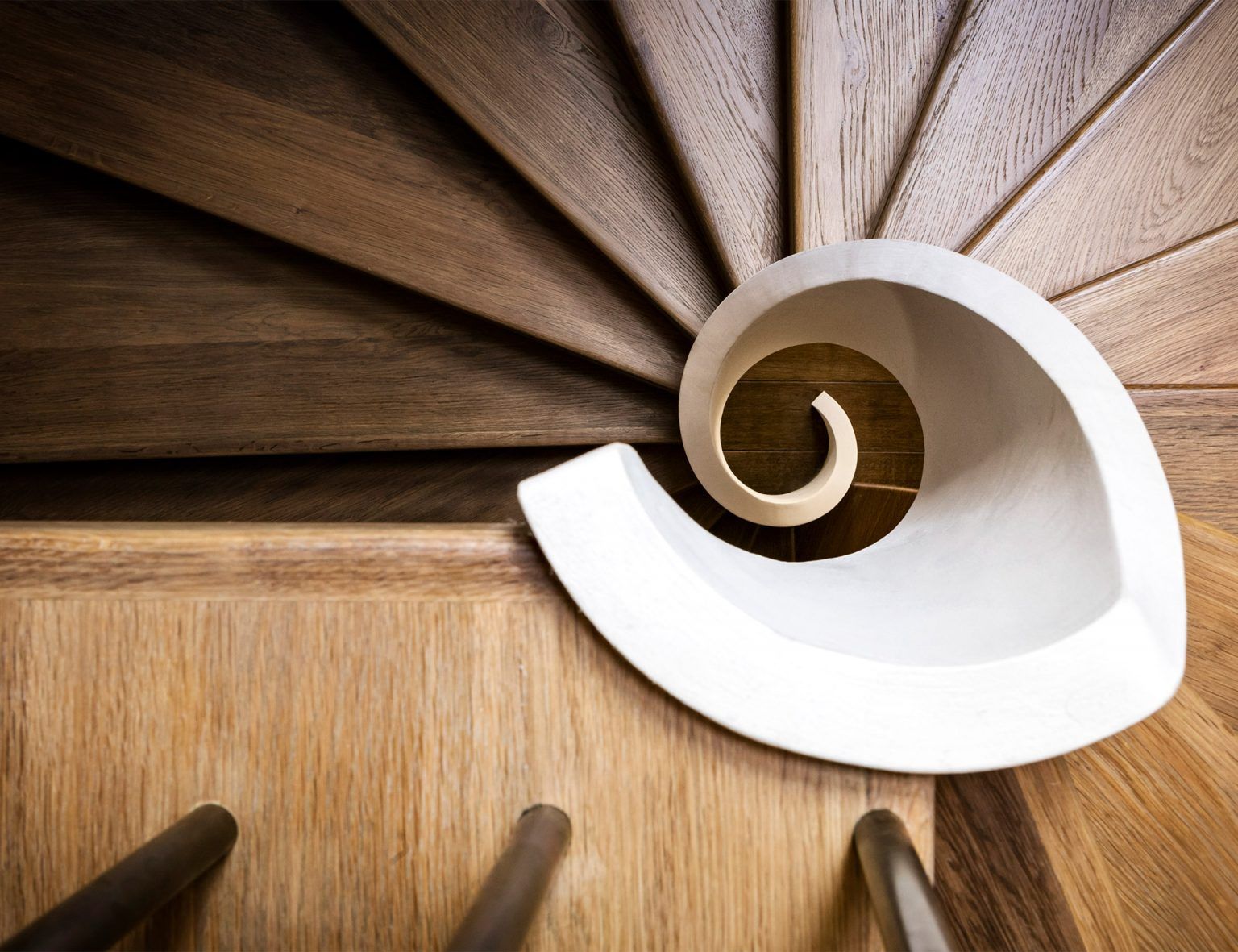 Eine Wendeltreppe aus Holz mit weißem Geländer