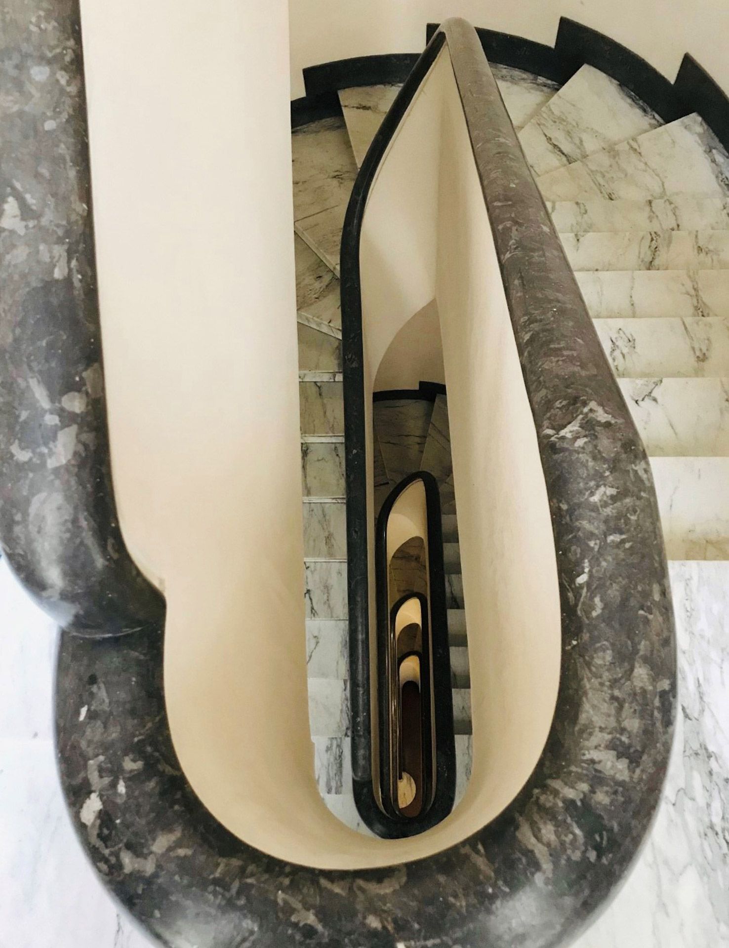 Eine Wendeltreppe mit Marmorgeländer und Stufen