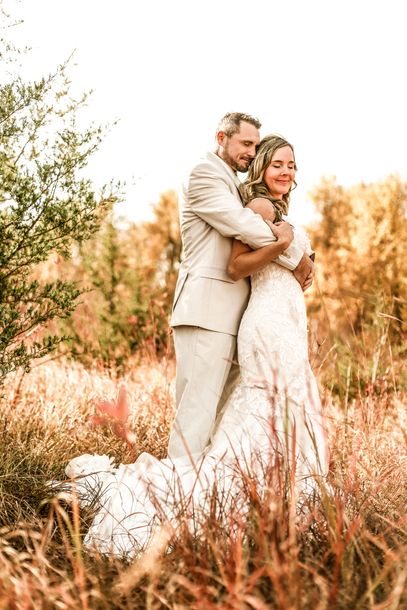 A man and a woman are kissing in a corn field.
