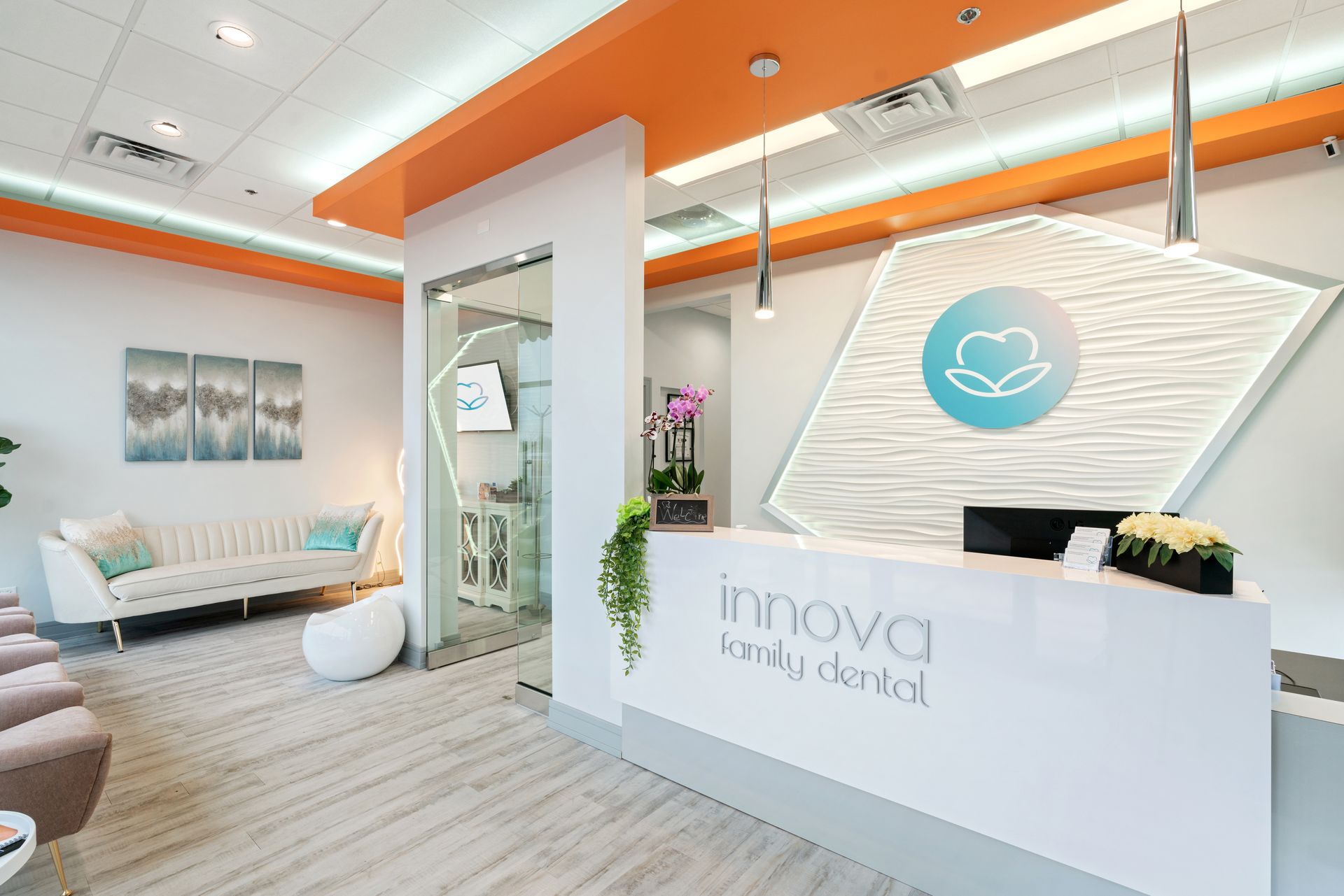 A dental office with a reception desk and a couch.