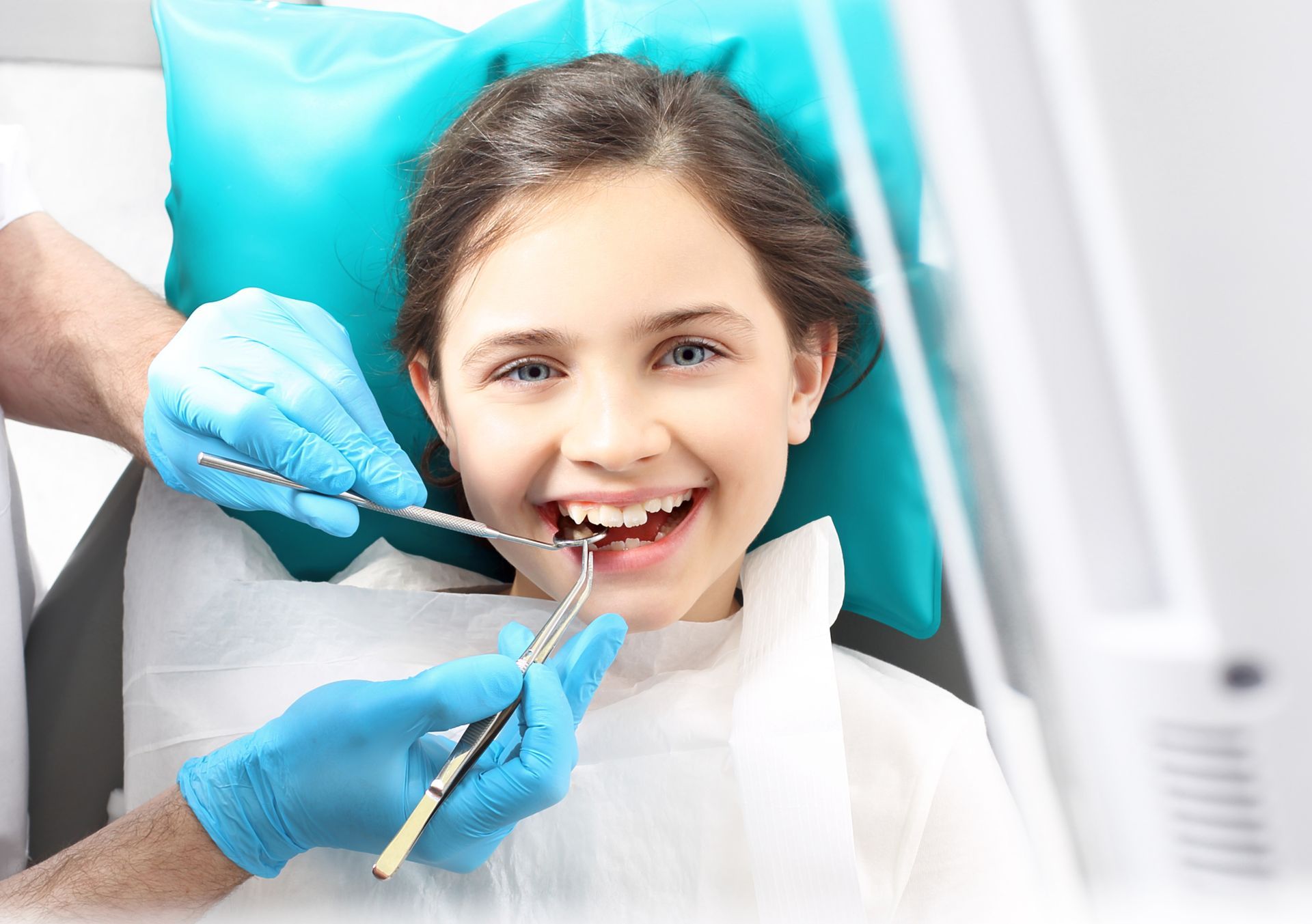 A young girl is having her teeth examined by a dentist.