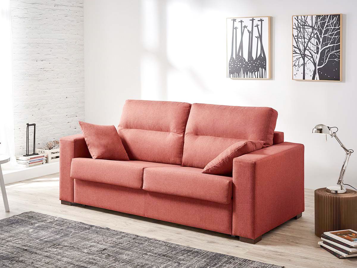 a living room with a red couch and two paintings on the wall