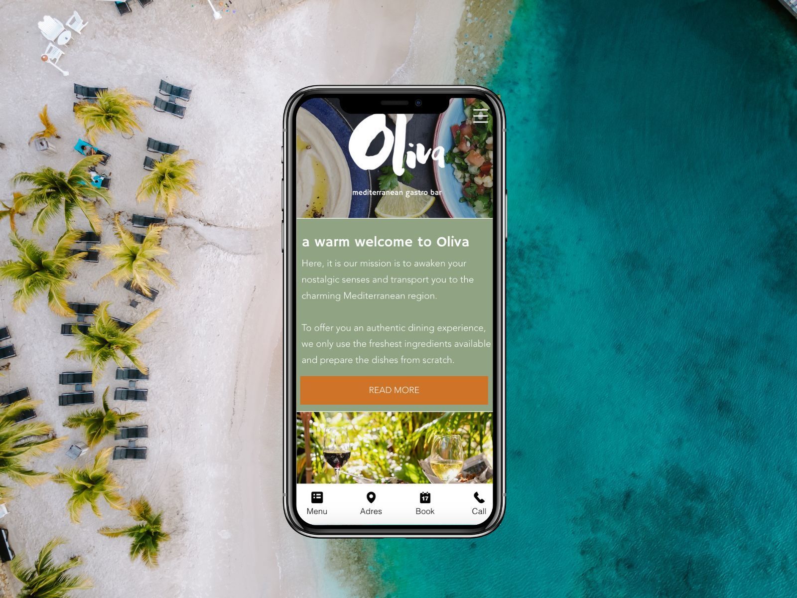 A cell phone is sitting on a beach next to a body of water.