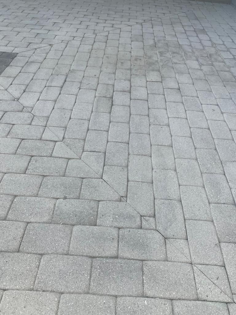 Gray brick pavers outdoors, with cracks between some.
