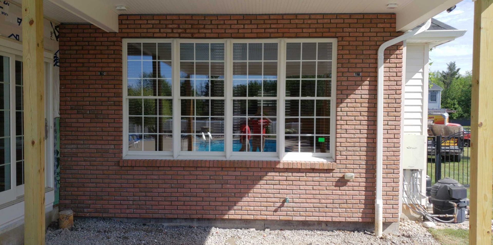 Brick house exterior with a large white-framed window and front porch columns