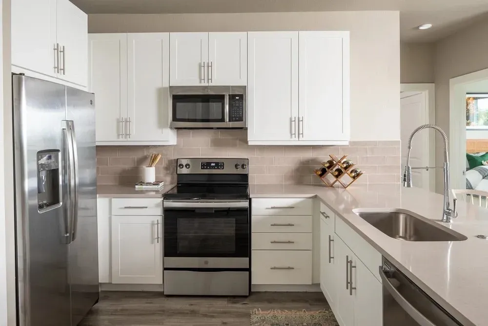Modern kitchen featuring stainless steel appliances and white cabinetry