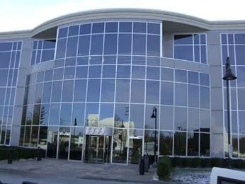 Our Modern Lake Success office building with large glass windows and a curved facade.