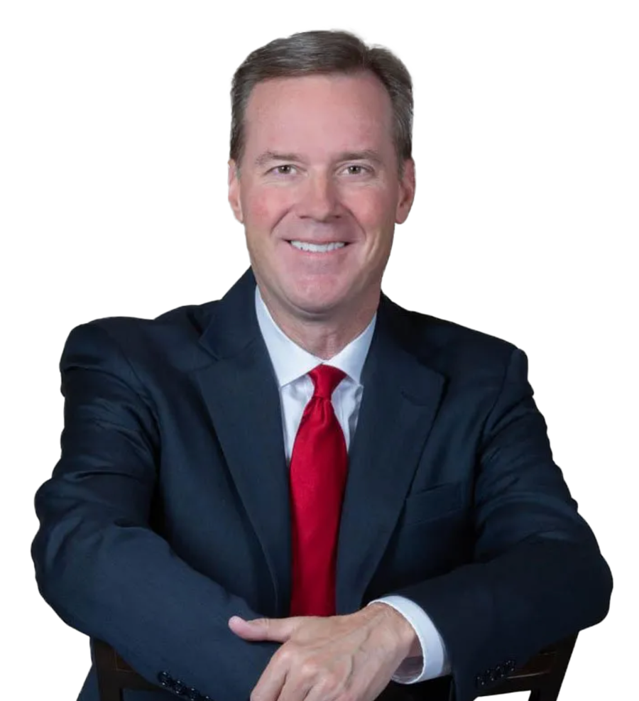 A man in a suit and tie is sitting with his arms crossed