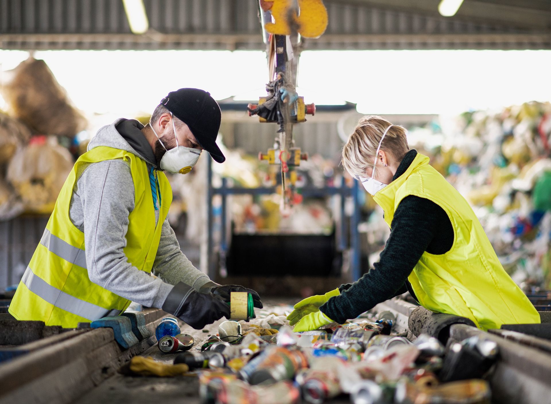 A man and a woman are working on a conveyor belt in a factory.
