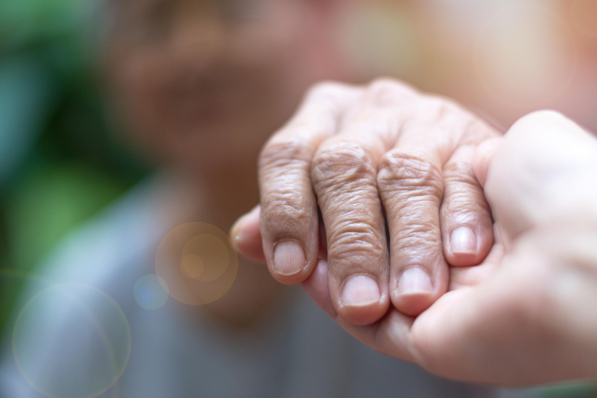 Hand of An Elderly Person Being Gently Held by Another Hand — Home Nursing Services in Liverpool, NSW