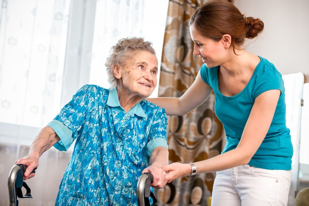 A Woman Is Helping an Elderly Woman with A Walker — Home Nursing Services in Sutherland Shire, NSW