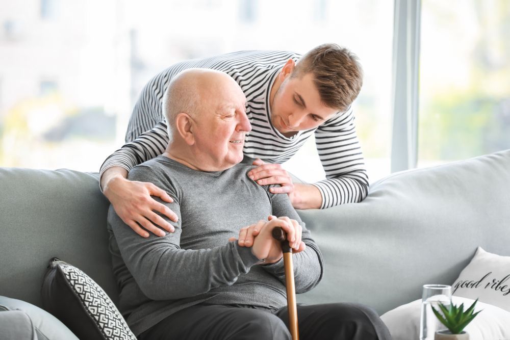 Two People on A Gray Sofa — Home Nursing Services in Campbelltown, NSW