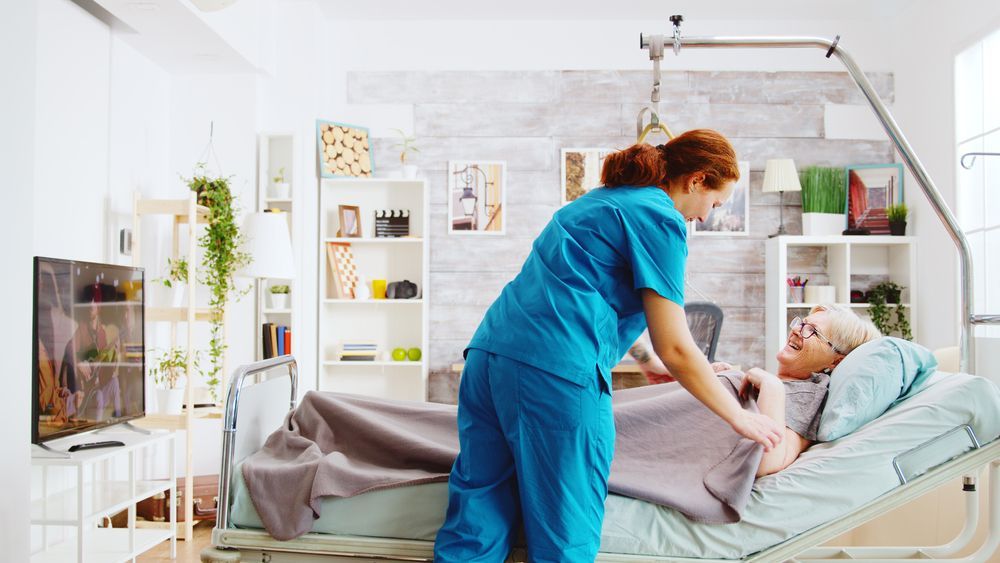 A Man is Using a Drill to Fix a Door Knob — Home Nursing Services In Port Macquarie, NSW