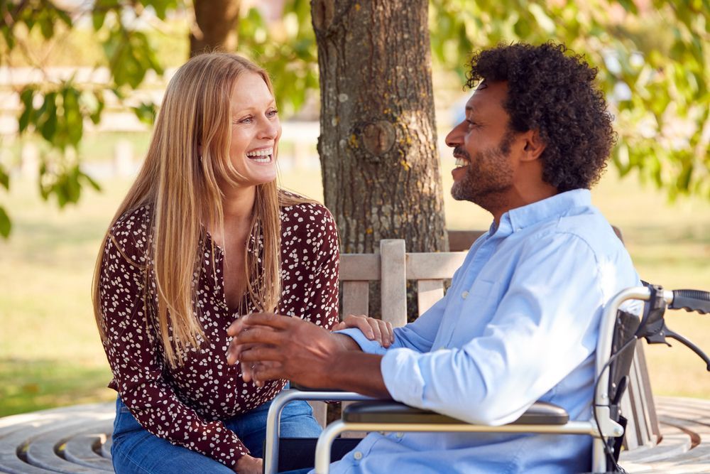 Two People Talking and Smiling Outdoors — Home Nursing Services in Lake Cathie, NSW