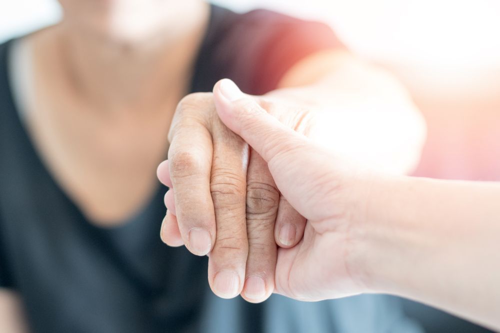 Two Hands Gently Touching, One Supporting the Other in a Soft — Home Nursing Services in Bankstown, NSW