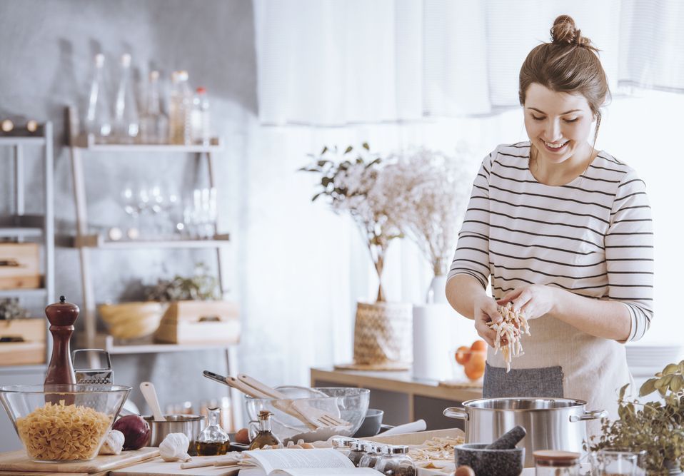 A Woman Is Preparing Food in A Kitchen — Home Nursing Services in Wauchope, NSW
