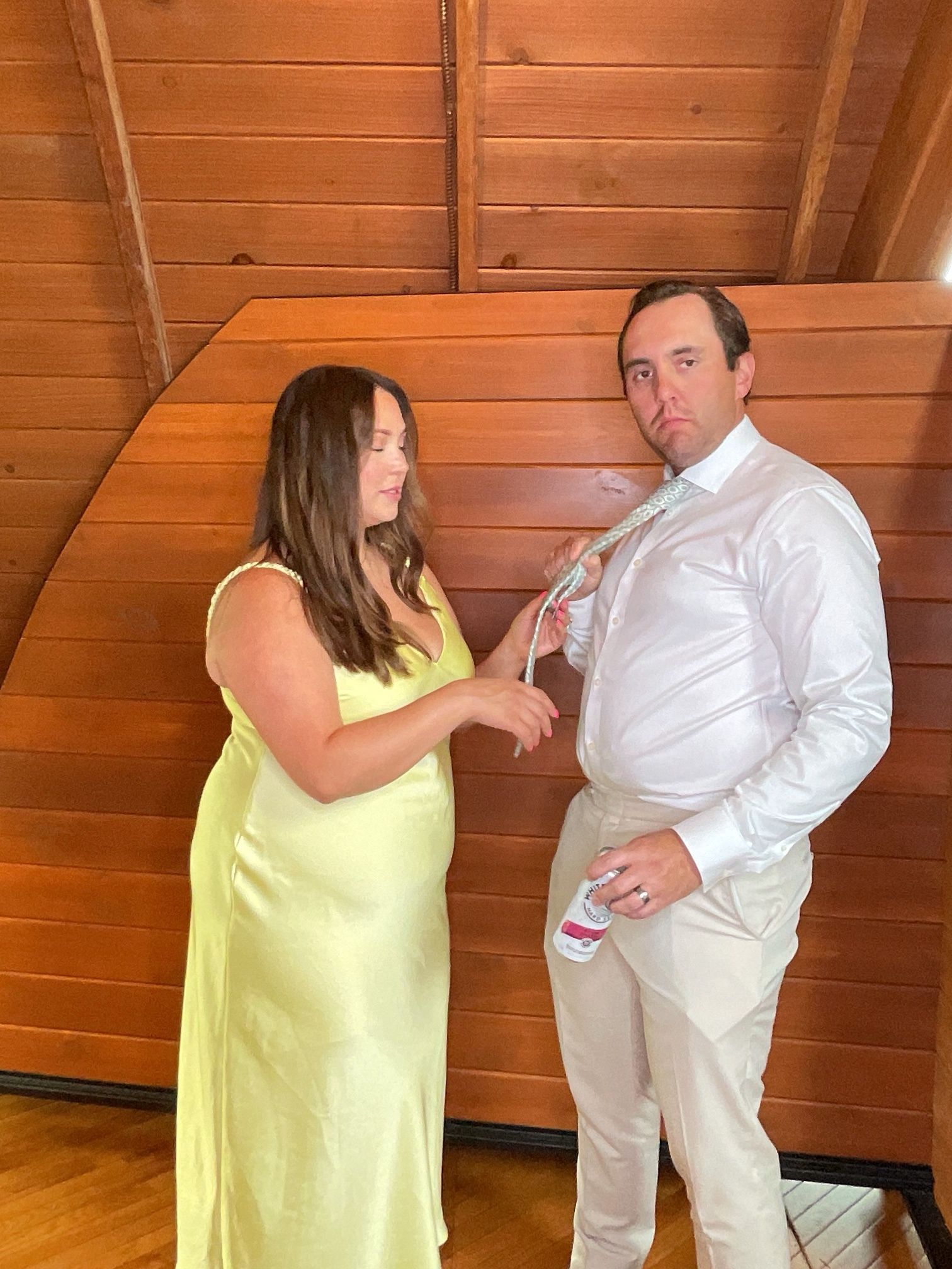 Two people standing indoors, one holding a microphone toward the other in a wood-paneled room.