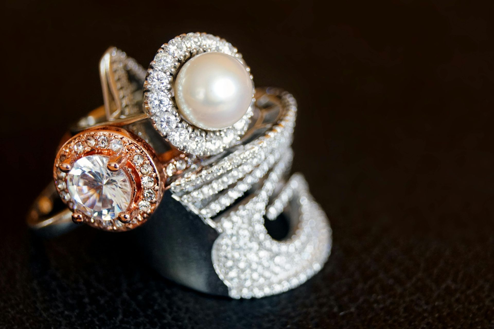 A pair of diamond stud earrings are sitting on a black surface.