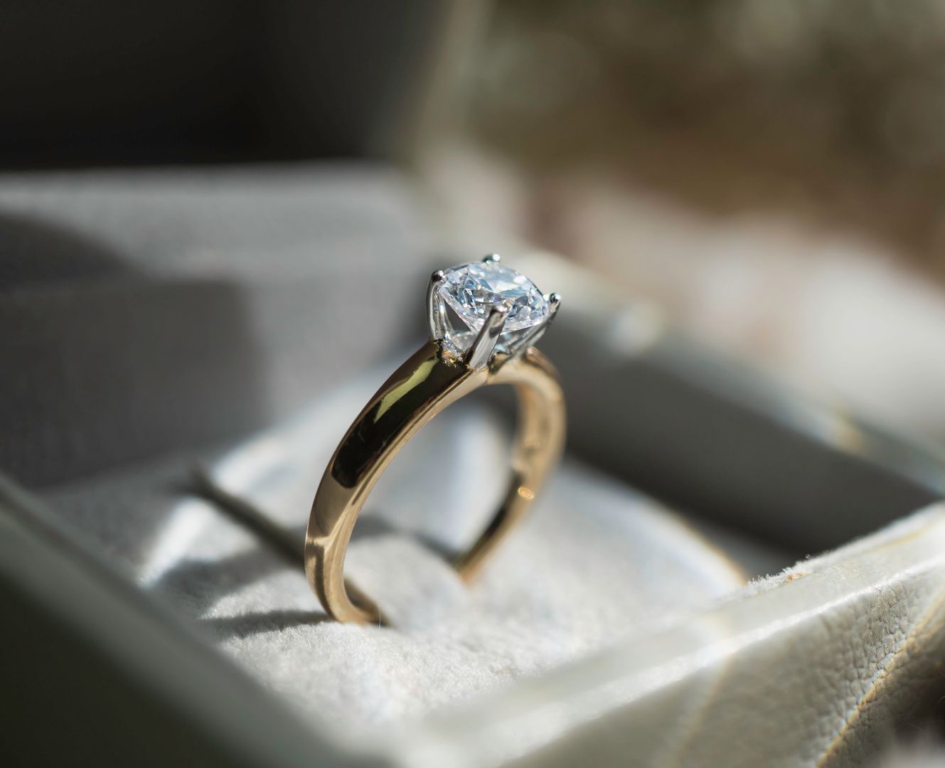A pair of diamond stud earrings are sitting on a black surface.