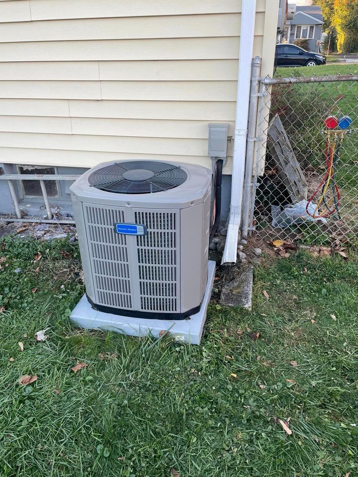 A large air conditioner is sitting on the side of a house.