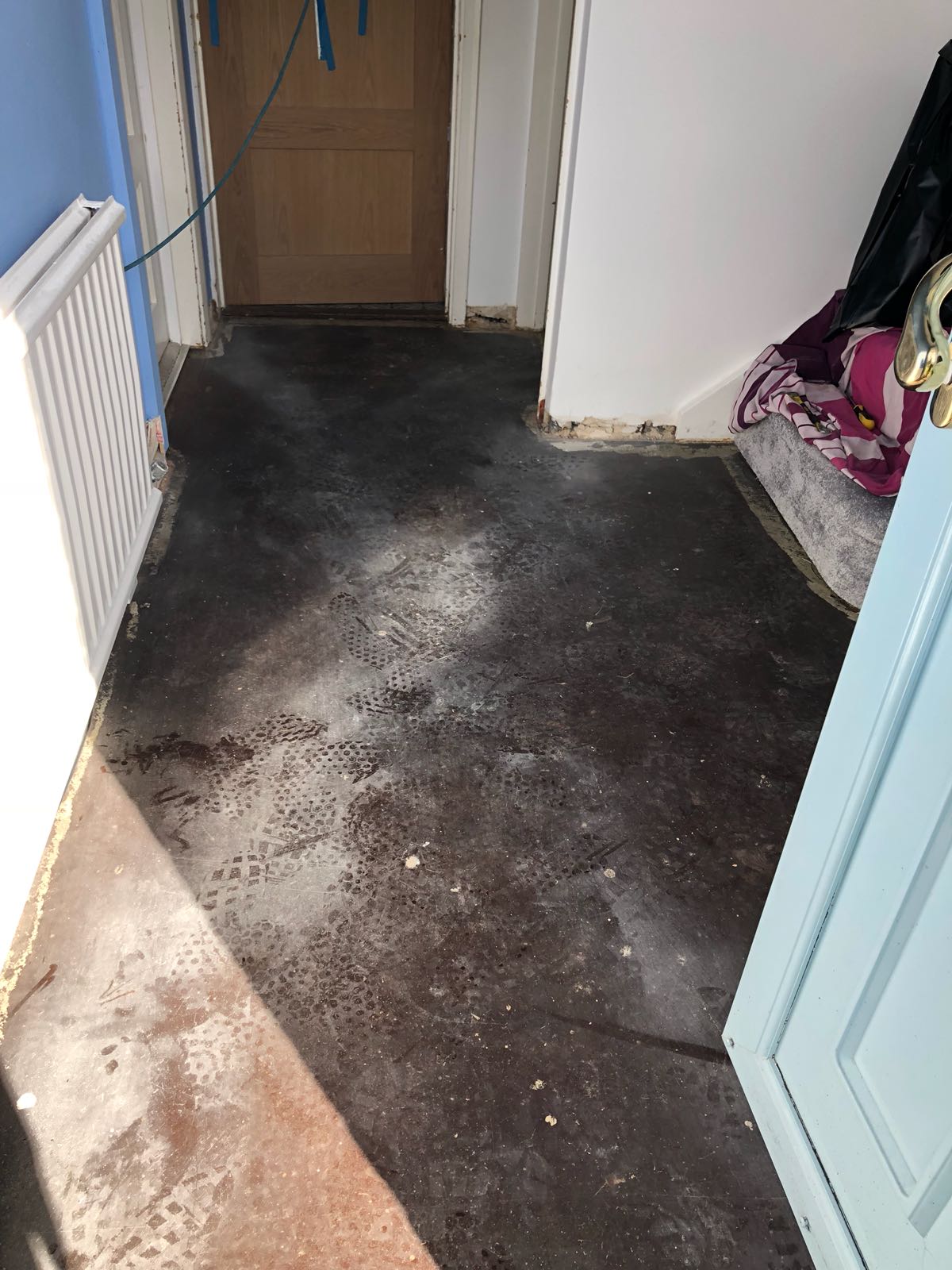 A room with a dirty floor and a door.