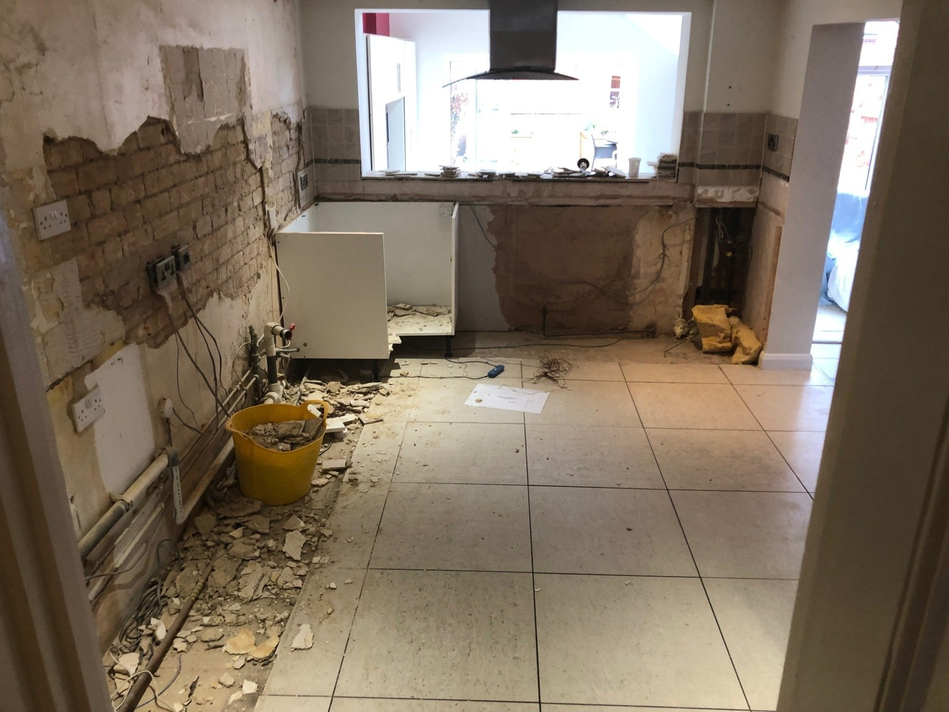 A kitchen under construction with a yellow bucket on the floor.
